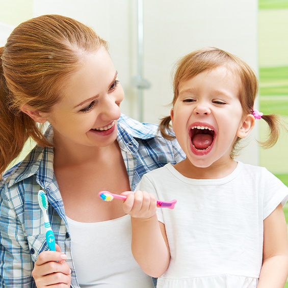 happy girl with her mom and a toothbrush